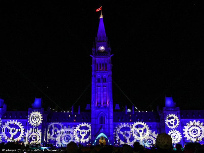 Images of a light show projected on the facade of a historic building at night