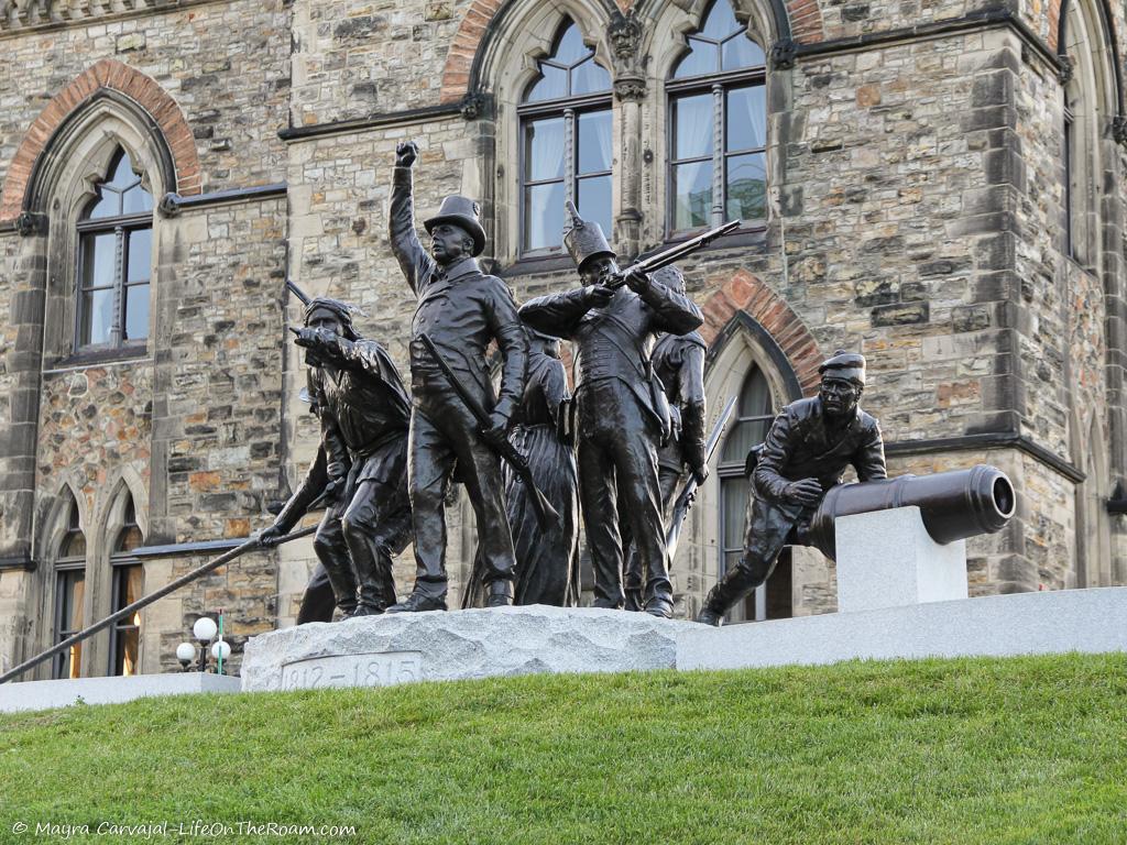 A bronze sculpture with seven figures in an outdoor setting