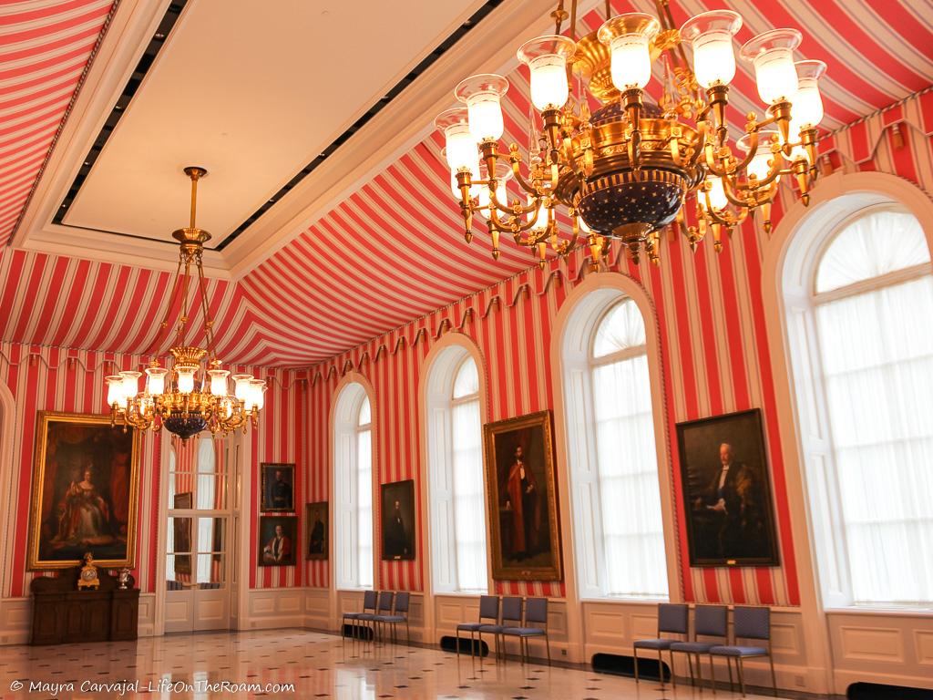 A light-filled room with walls and ceiling covered in red and white stripe fabric