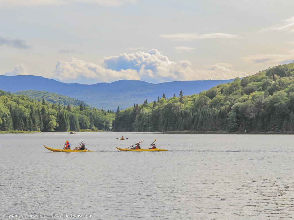People kayaking on a lake with mountains in the background