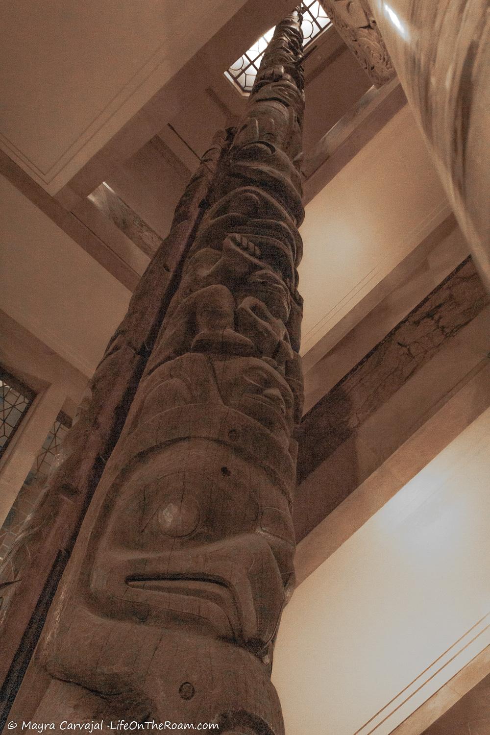 A tall totem pole inside a building