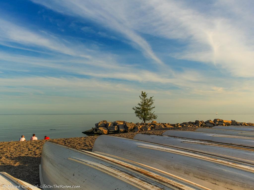 A beach with canoes and a blue sky