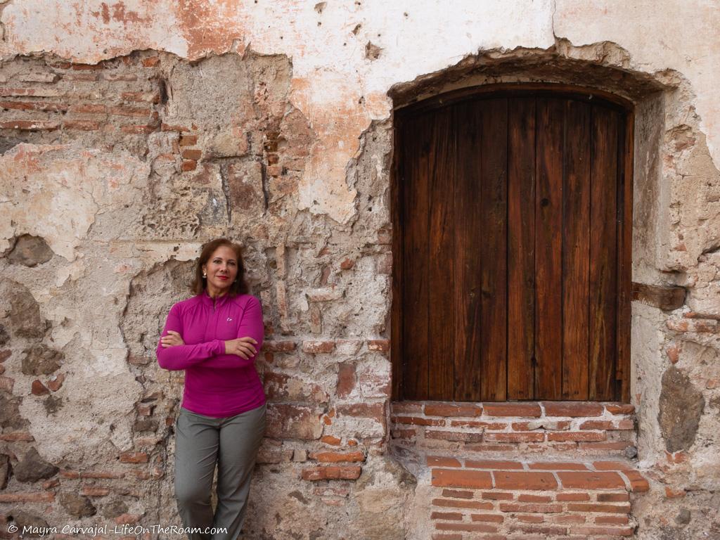 Mayra standing in front of the wall of a historic building