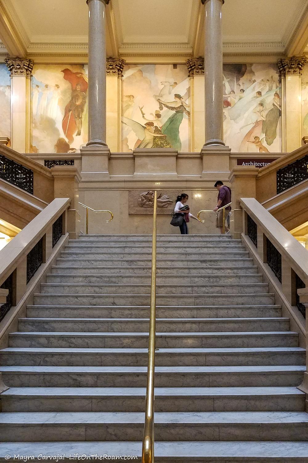 A big marble stair with art painting at the top