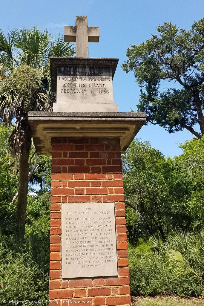 A brick monument with a cross on top