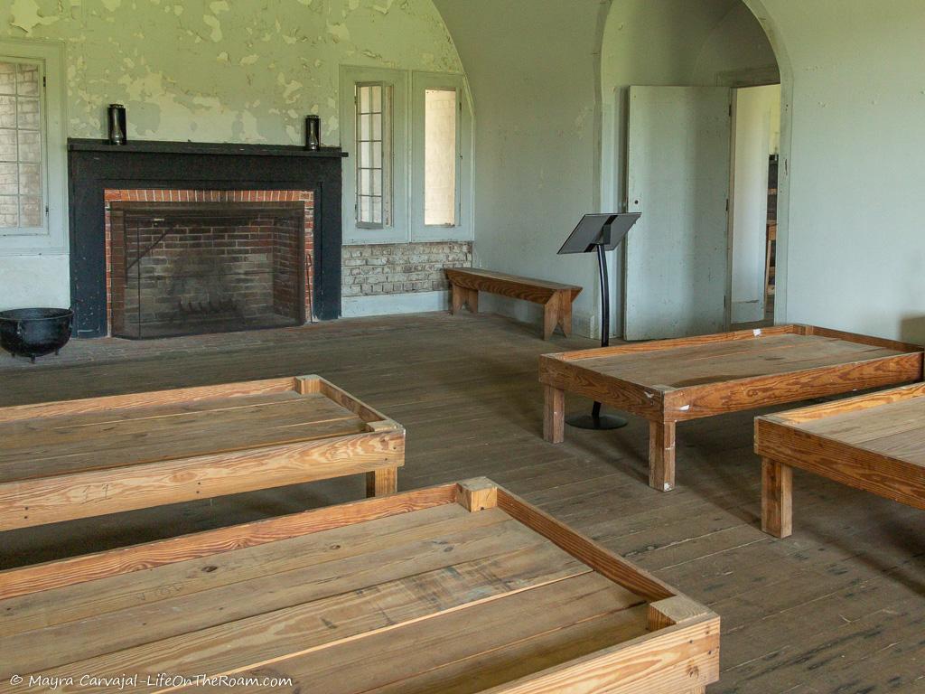 A room with wooden-frame beds and a fireplace