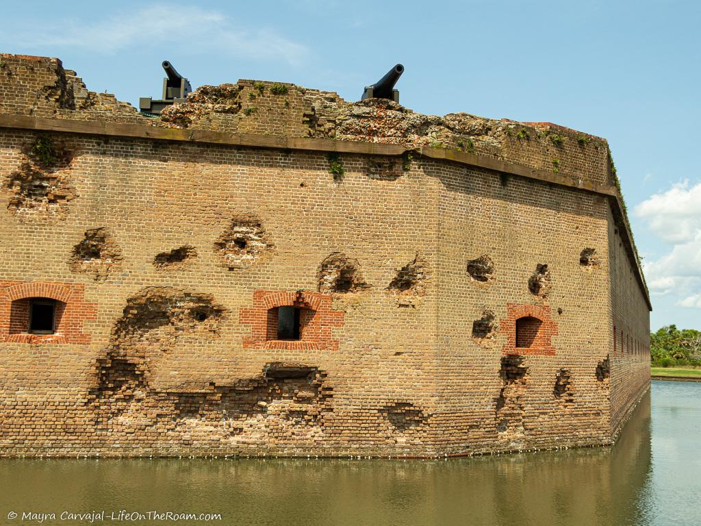 An old fort with ammunition scars and cannons on top