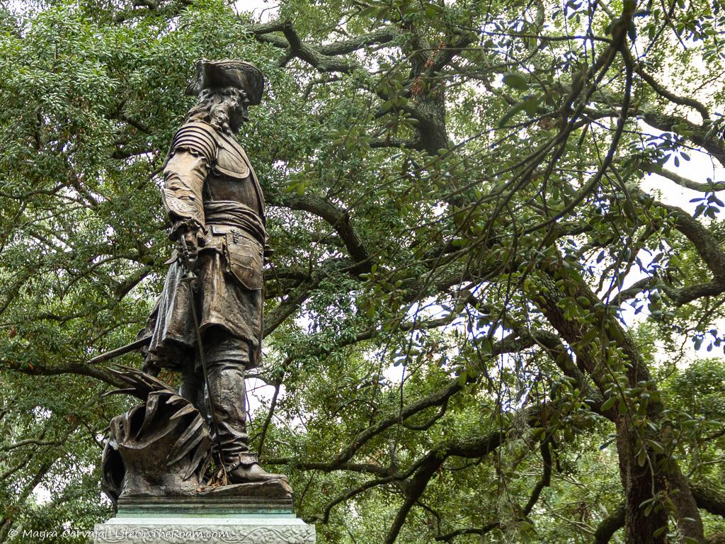 A statue in a park with treess