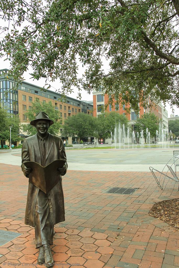 An urban park with a fountain and a statue