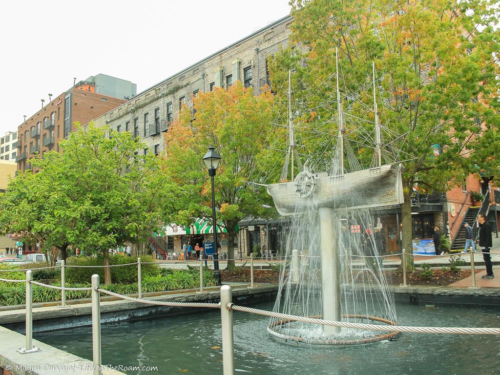 A fountain shaped like a boat in an urban park