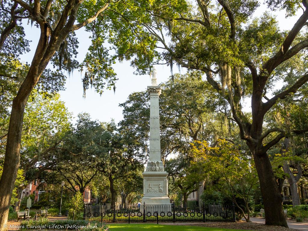 A square with large trees and a marble monument