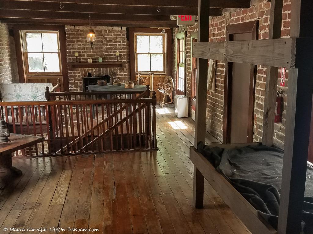 A simple room with wood floors, bunk beds and a fireplace