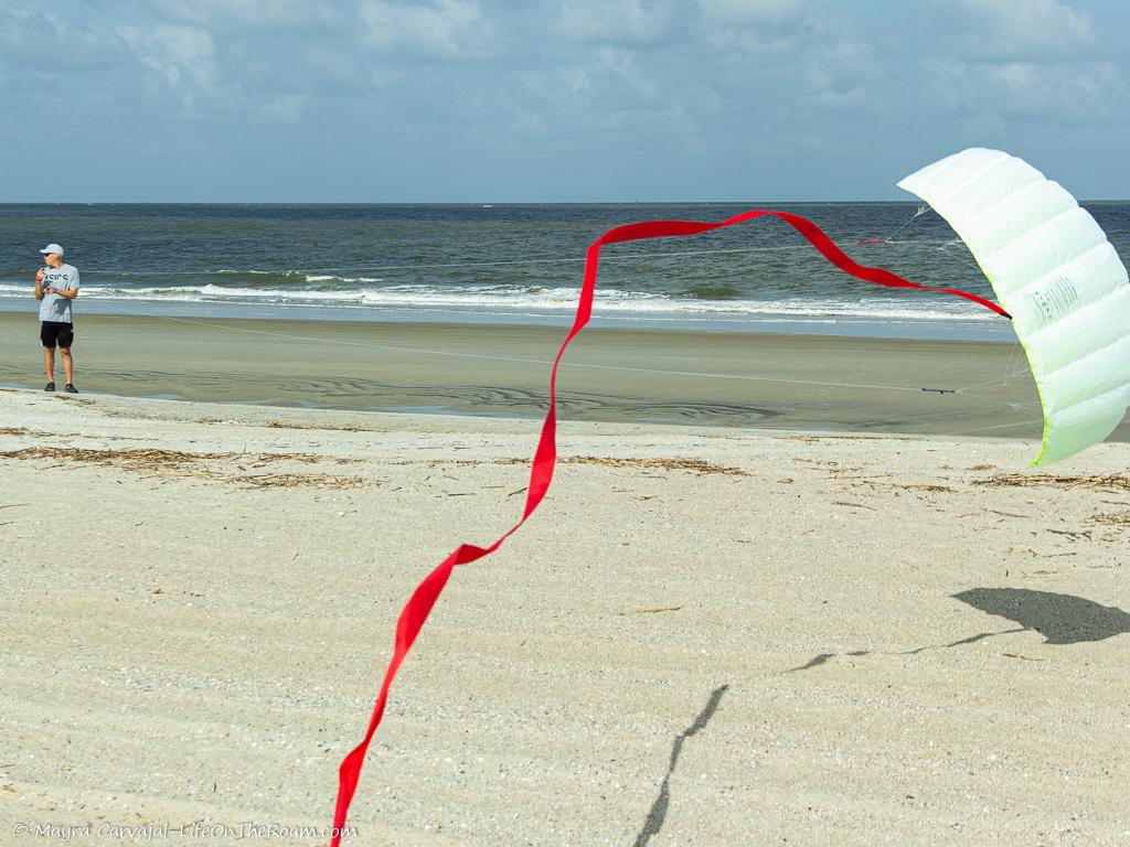 A man flying a kite on a sandy beach