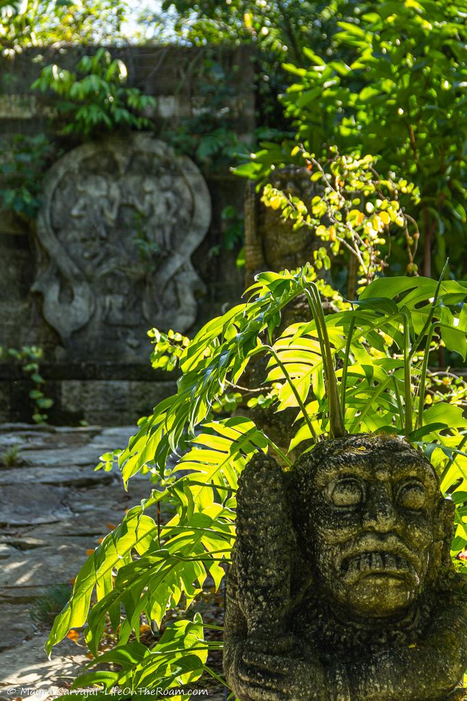 A garden with carved stones featuring Javanese motifs