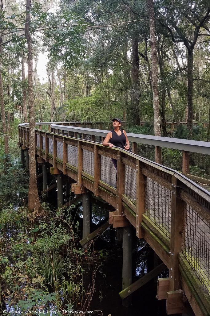 Mayra standing on a boardwalk among trees