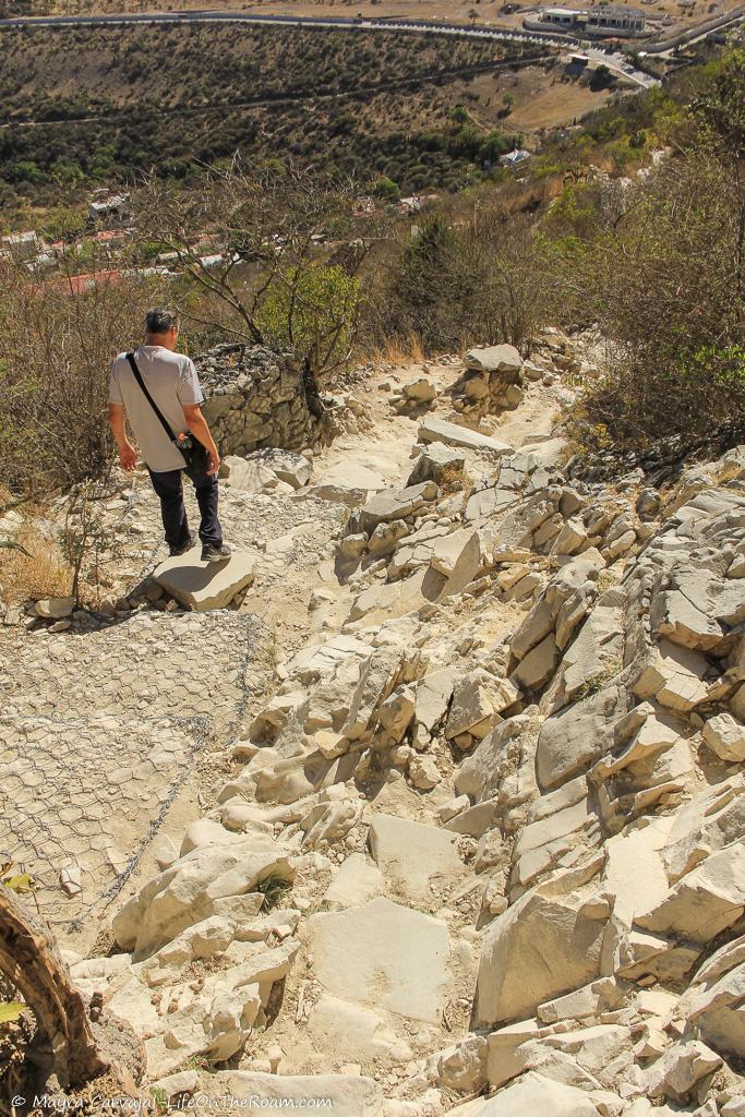 A man walking down a steep trail