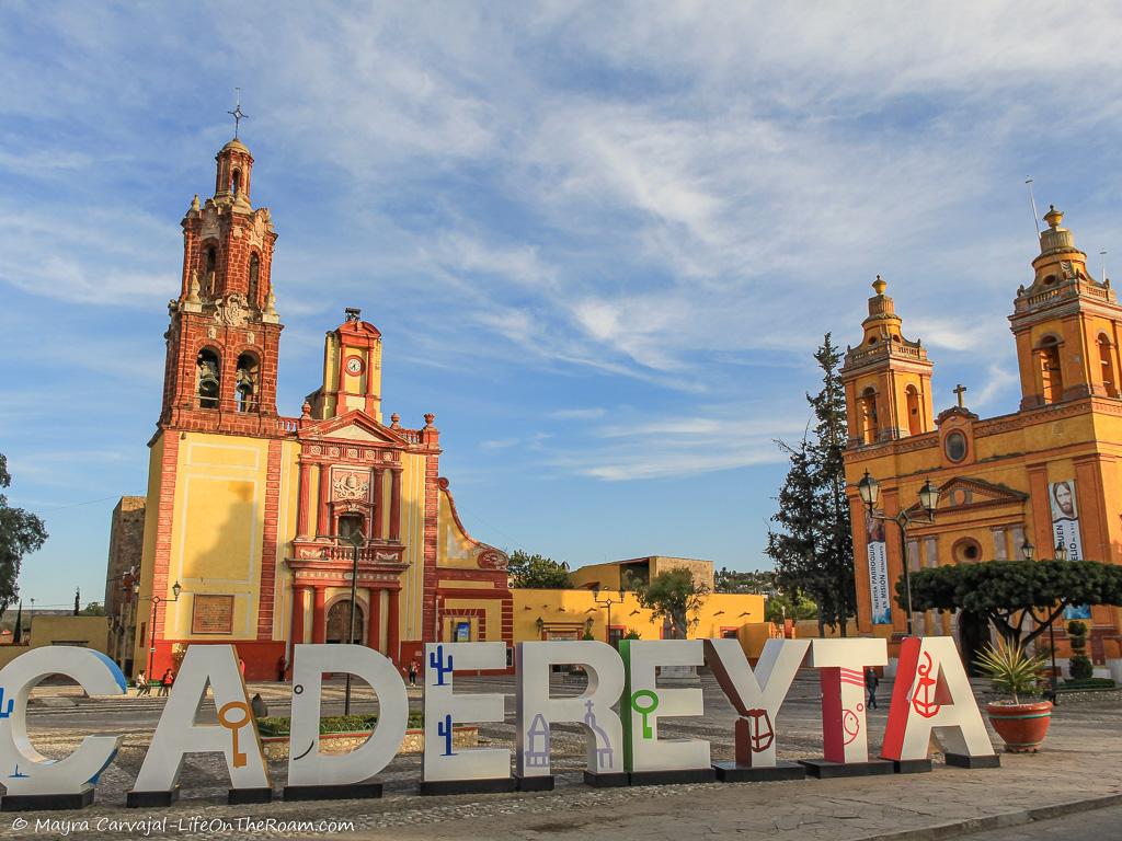 Two large churches behind a sign saying CADEREYTA