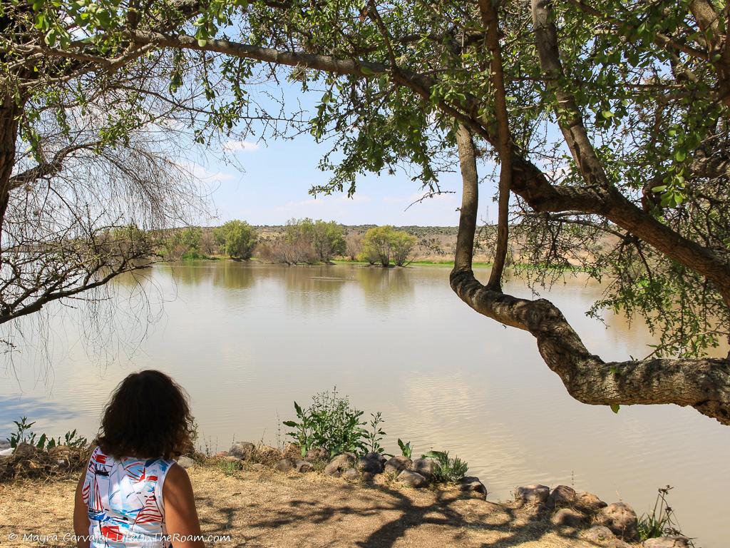 Woman sitting at the banks of a water reservoir