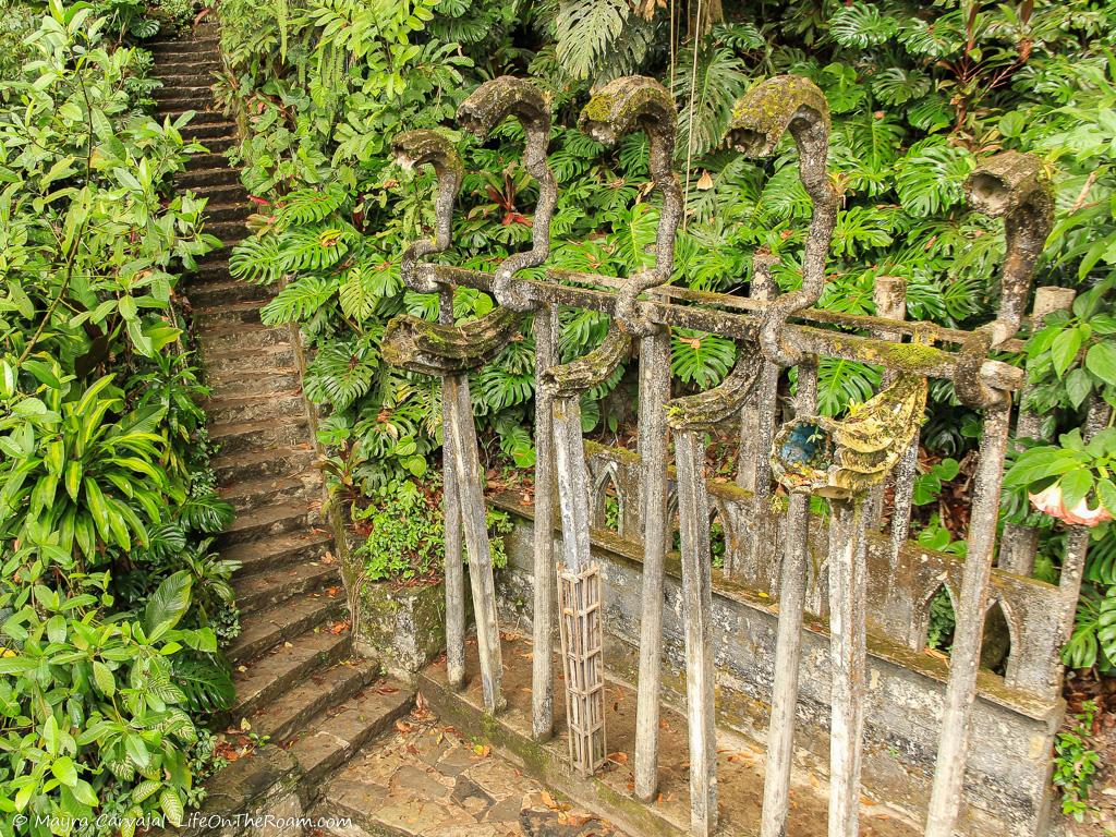 An aerial view of stairs outdoors with a sculpture in a lush garden