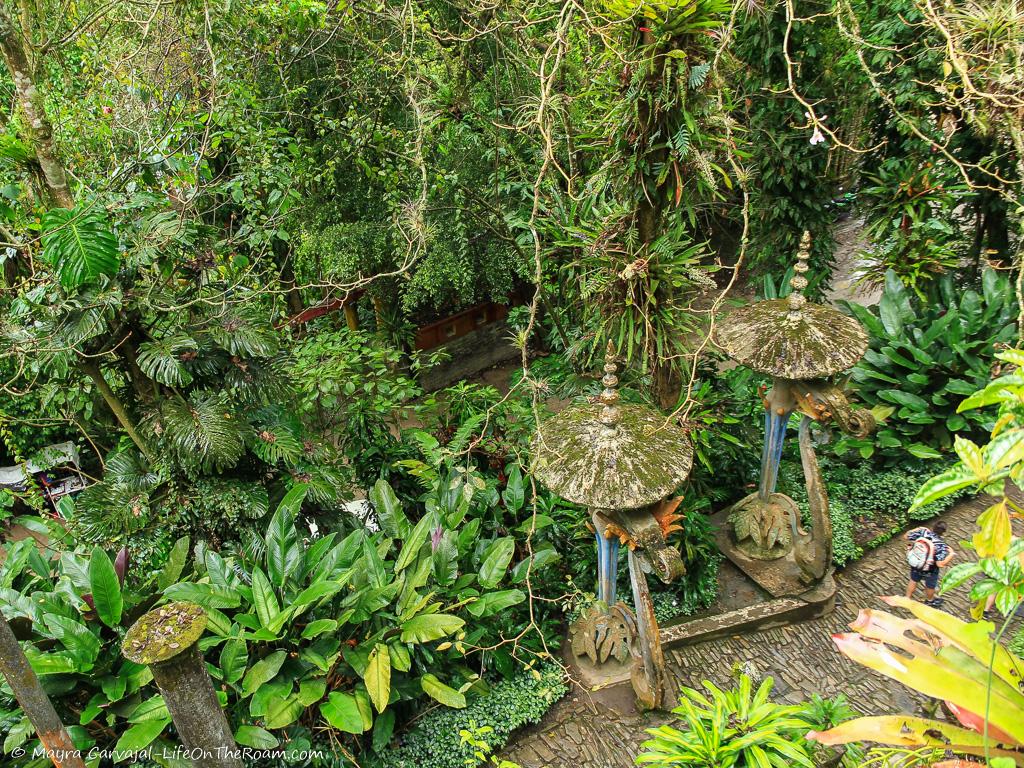 An aerial view of a garden with sculptures in a dense jungle
