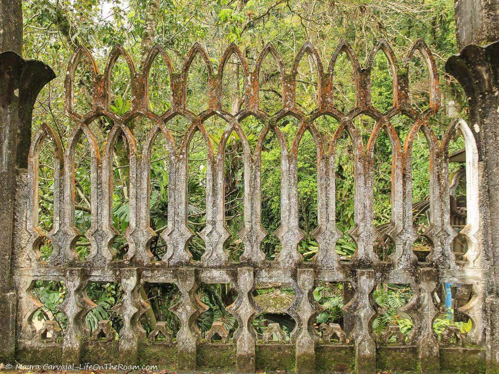 A concrete lattice with greenery behind