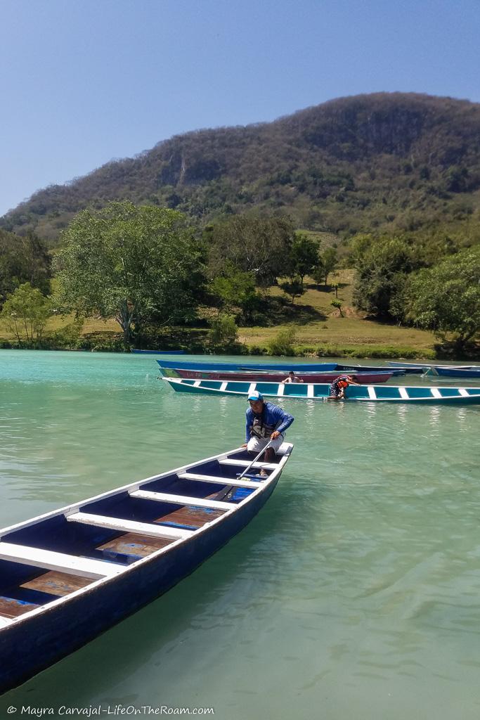 Boats on a river with mountains in the background