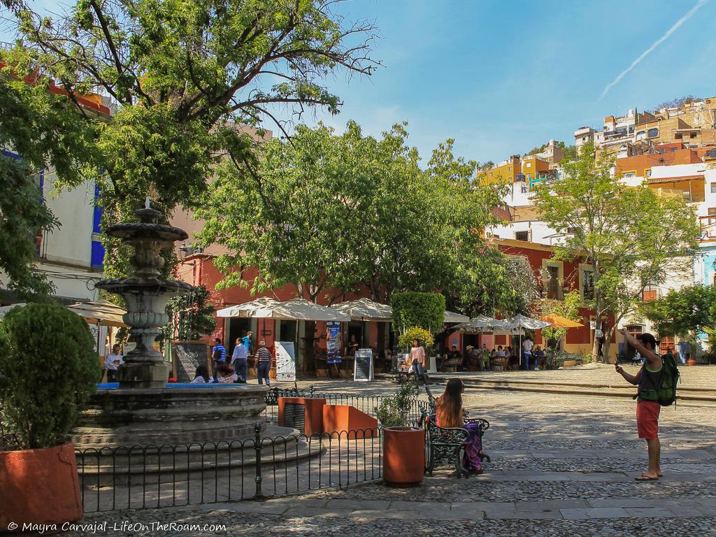 A square with a fountain and trees