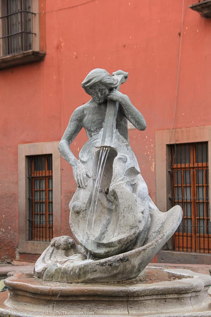 A fountain in the shape of a triton playing a cello