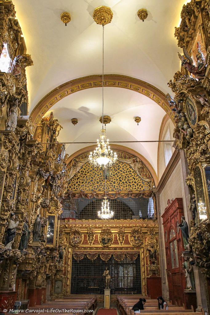 Highly detailed carved wood altars on the sides of a church interior