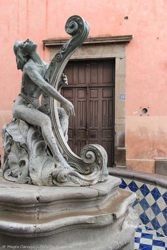 A fountain with the sculpture of a woman playing the harp