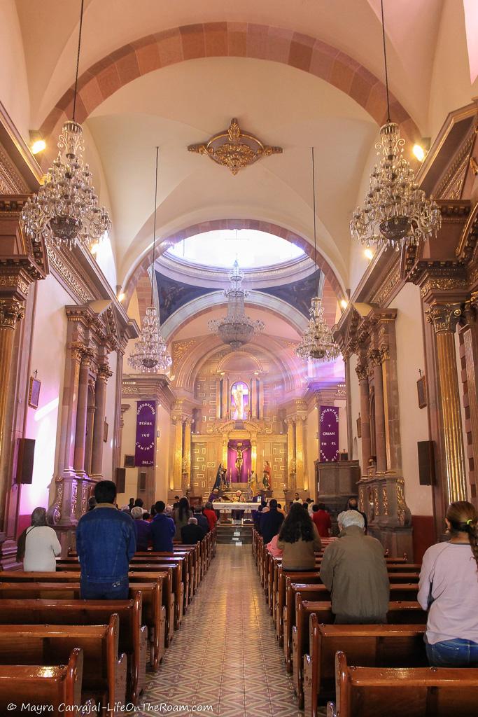 The inside of a church with a golden altar