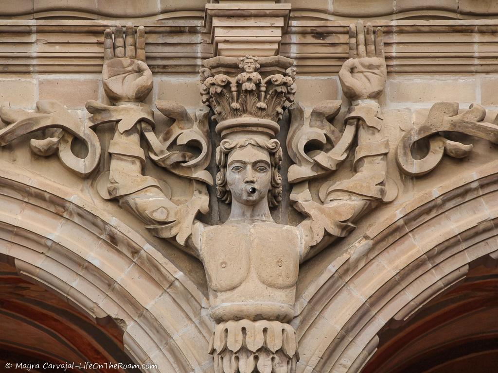 A sculpture on a human figure adorning the façade of a building