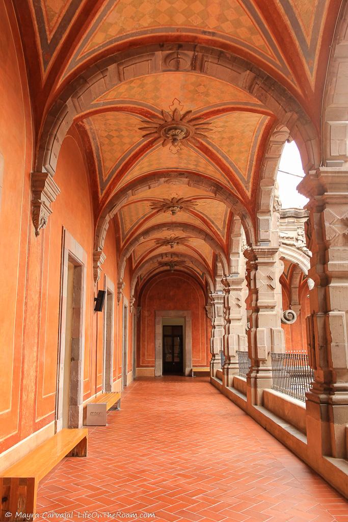 A corridor with a painted vaulted ceiling