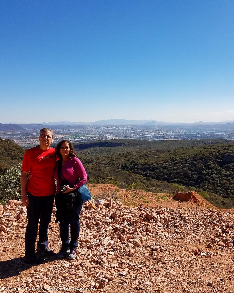 A couple at the edge of a mountain with a view