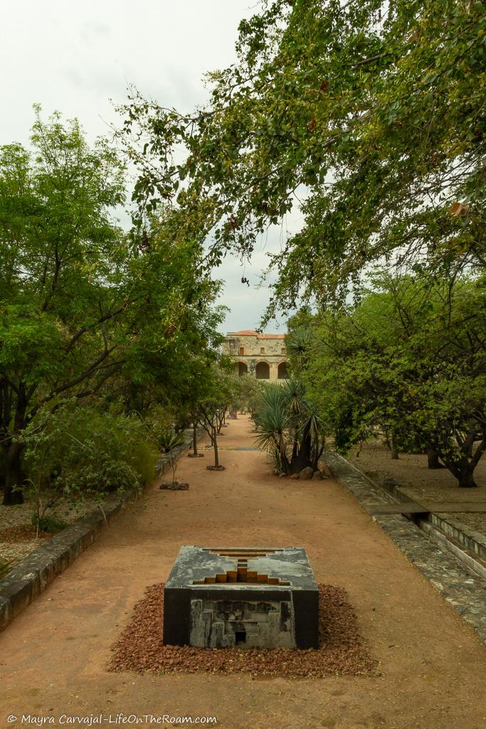 A garden with a promenade and a historic piece in the middle