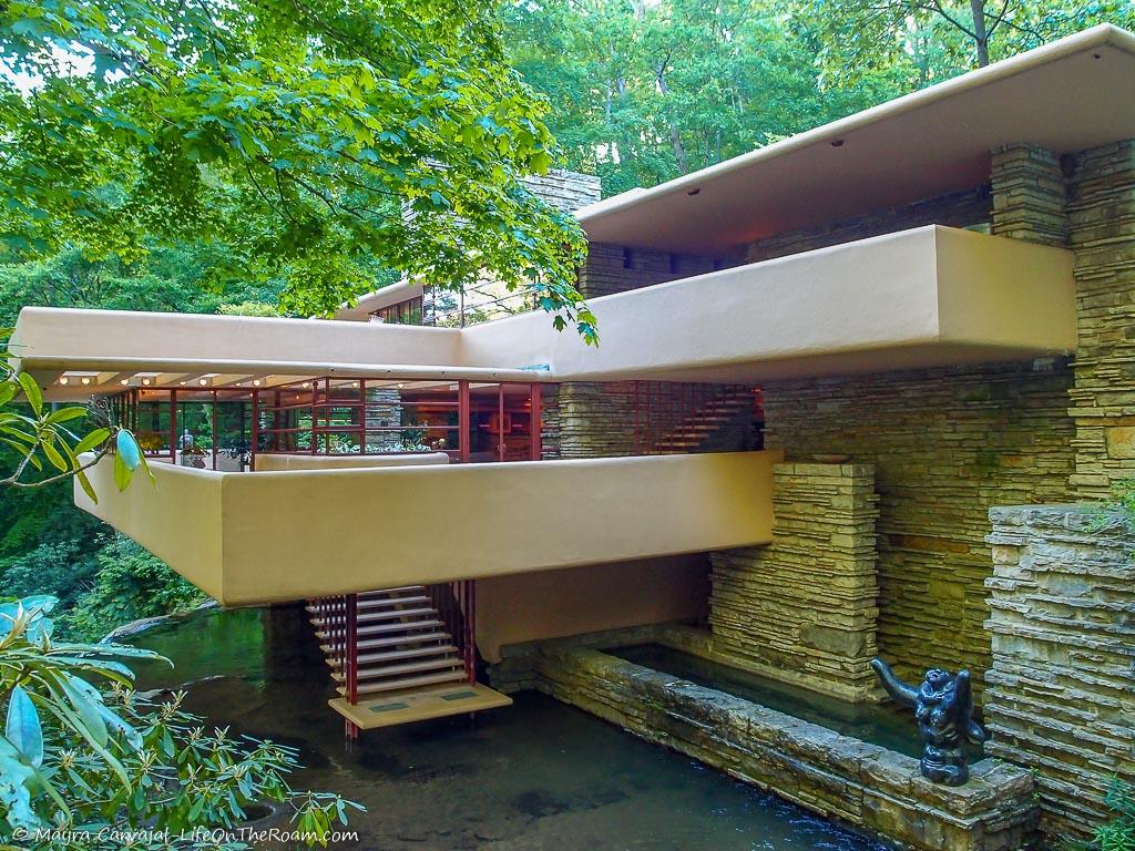 A house with stairs leading to a stream