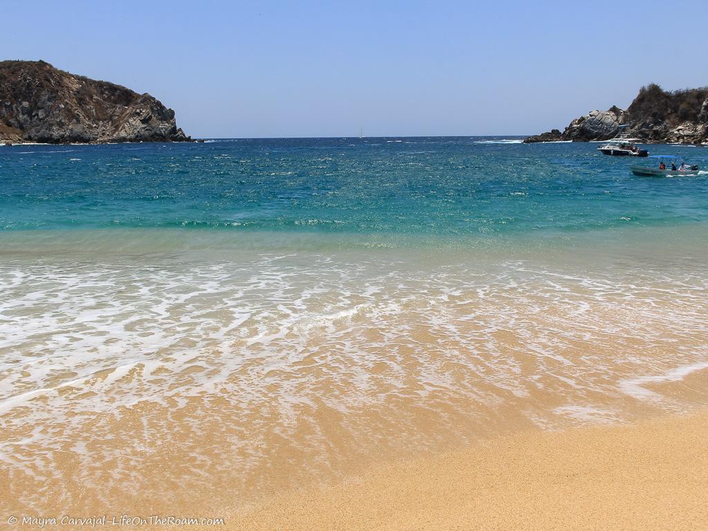 A sandy beach with rocks in the background