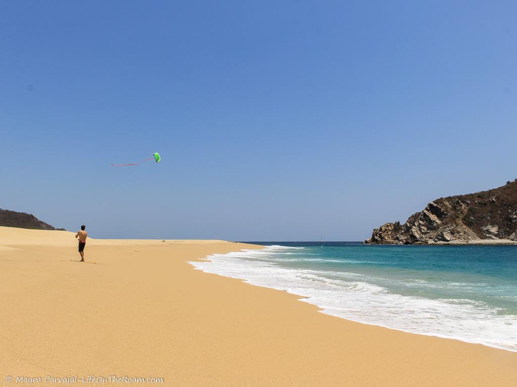 A man flying a kite in a solitary beach