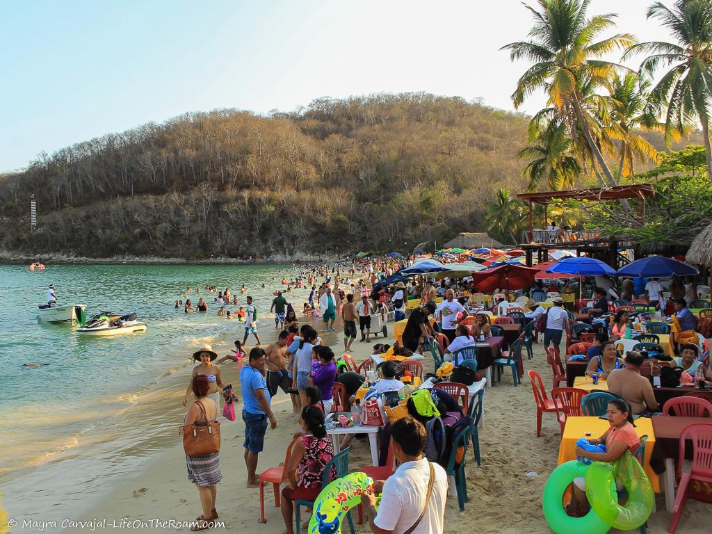 A crowded beach with tables and chairs