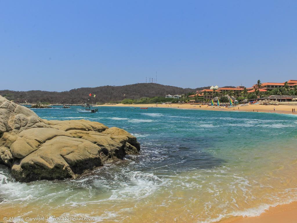 View of a beach with hotels and rocks in the ocean