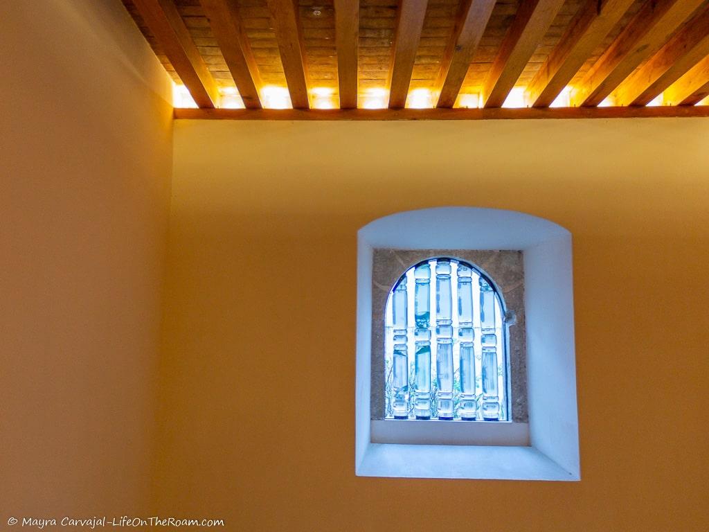 A window with glass bars and lighting in the ceiling
