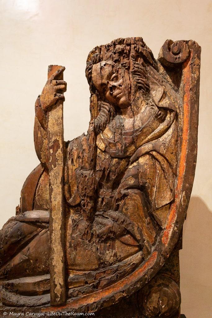A carved wood piece of a reclined woman