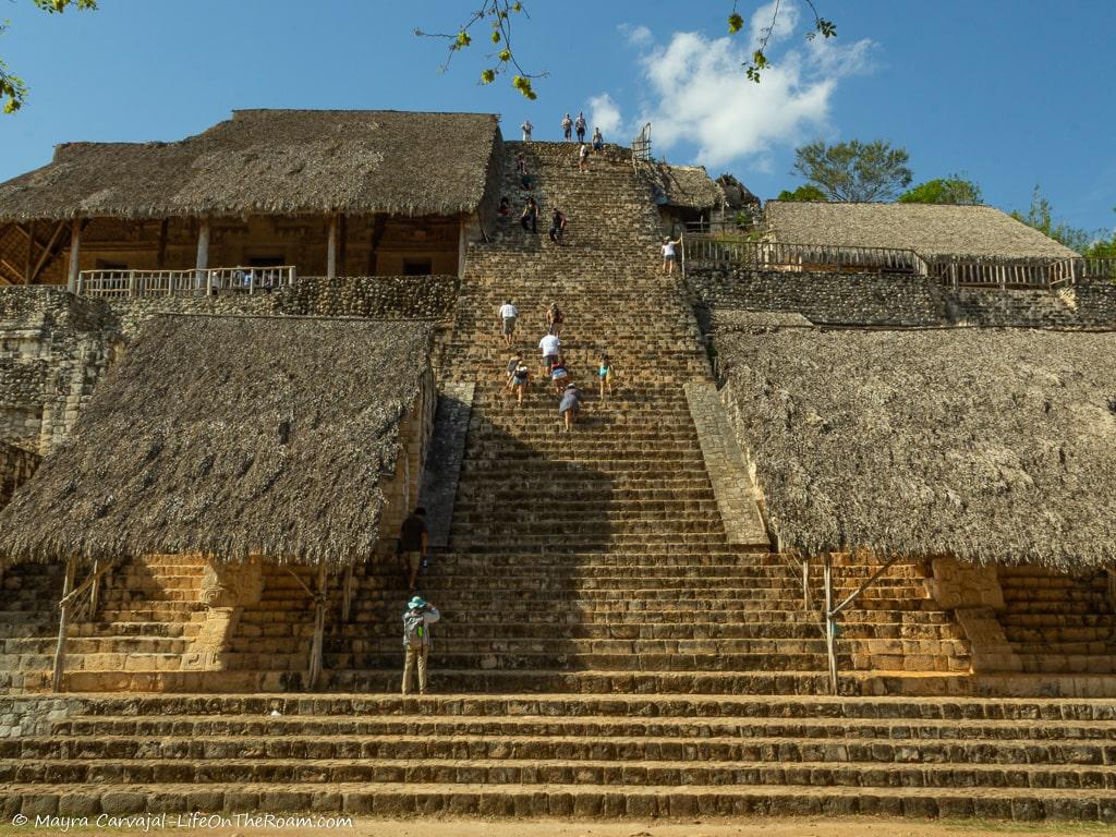People climbing a steep pyramid
