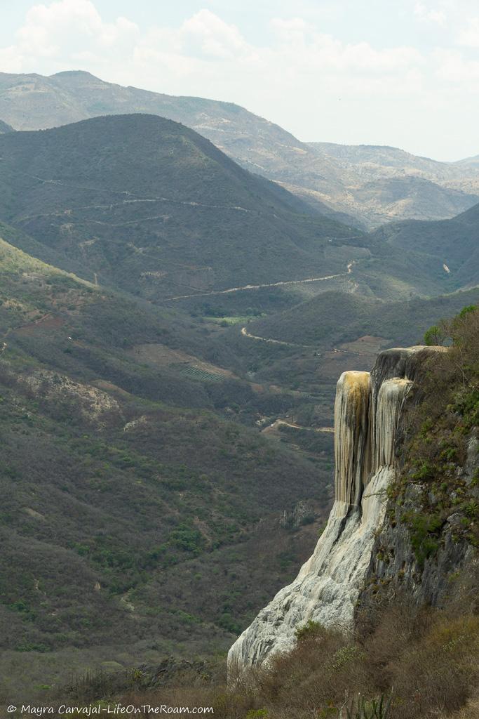 A calcified waterfall with a backdrop of mountains