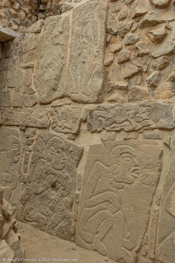 Bas-reliefs of warriors carved in stones in the façade of an ancient temple