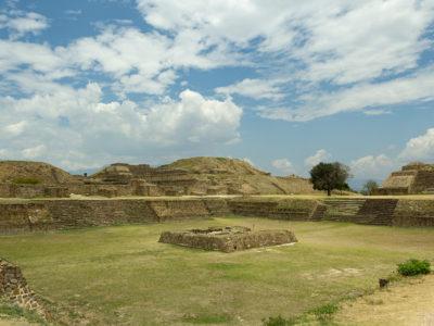 A sunken patio surrounded by stone pyramids in an archeological site