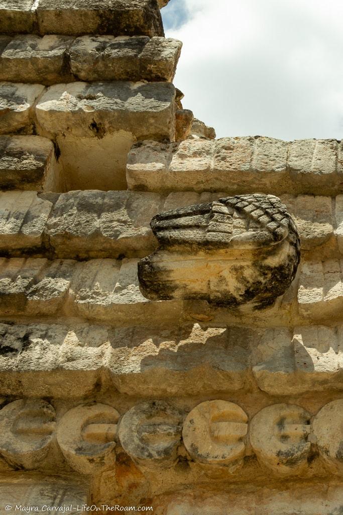 An upper facade with stone carvings resembling a thatched roof