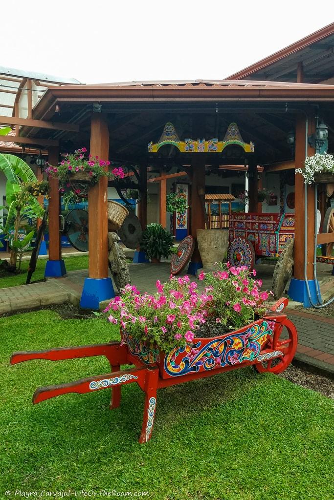 A decorated oxcart with flowers in a garden