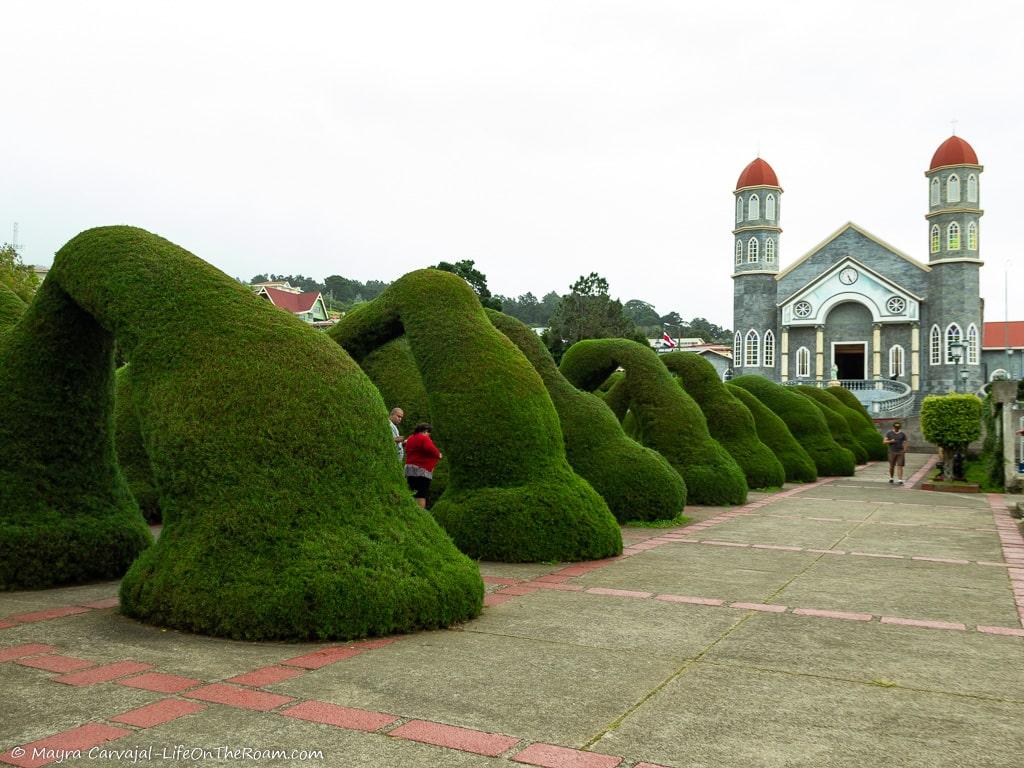 Arches made of topiaries with a church at the end