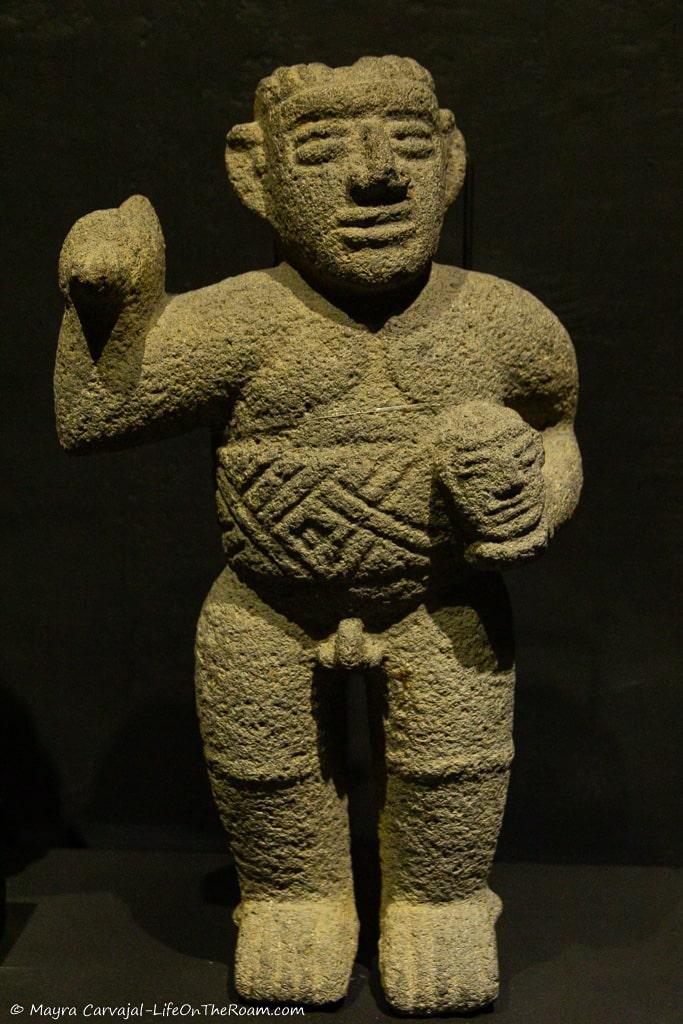 A stone figure of a man carrying a head in his hands